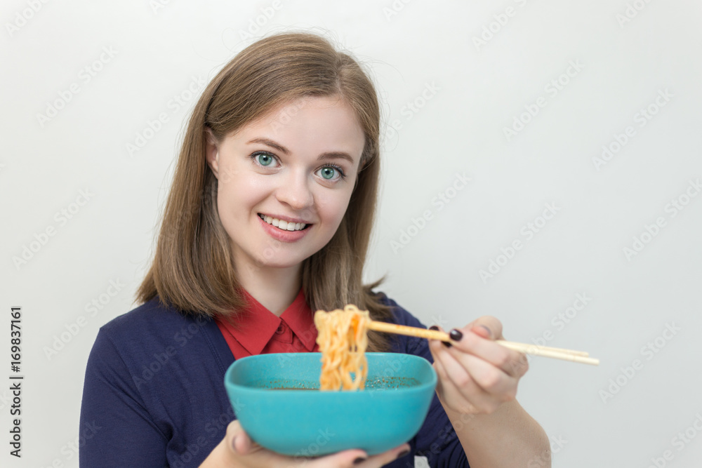 Young caucasian girl eating noodles using chopsticks Young caucasian girl eating noodles using chopsticks