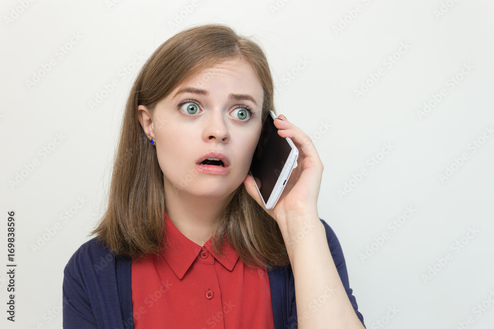 Young caucasian girl with a smart phone, frightened, upset, scared Young caucasian girl with a smart phone, frightened, upset, scared