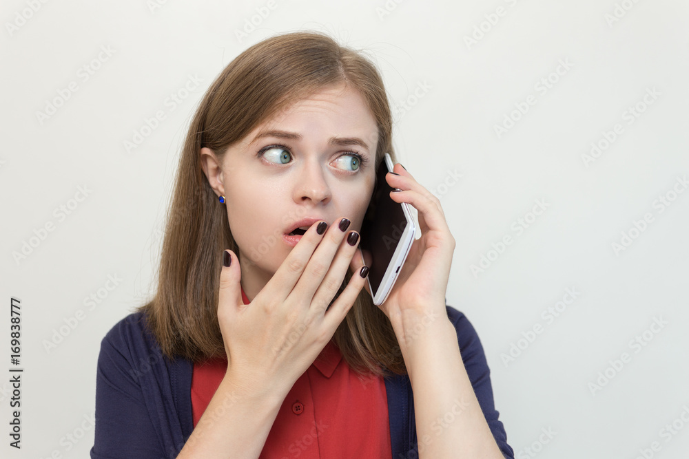 Young caucasian girl with a smart phone, frightened, upset, scared Young caucasian girl with a smart phone, frightened, upset, scared