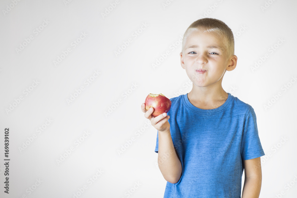 Portrait happy, smiling boy eats an red apple. Portrait happy, smiling boy eats an red apple.