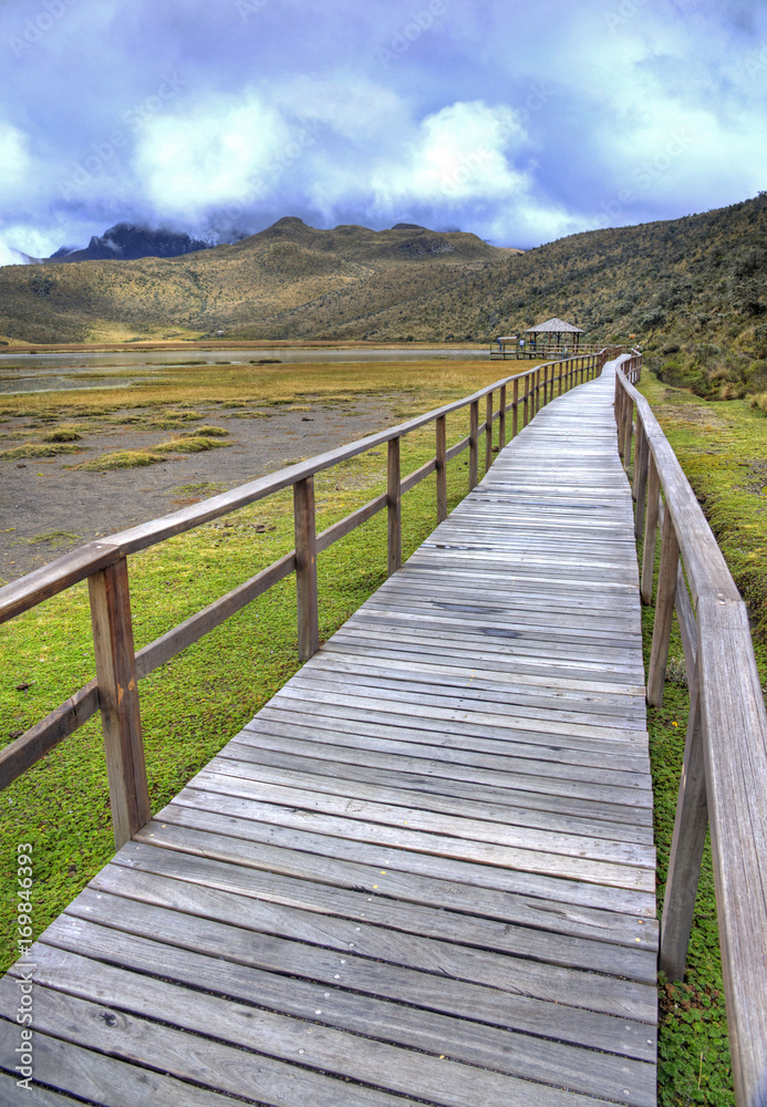 Wooden walkway that leads to the Limpiopungo Lake in the Cotopaxi National Park, on an overcast rainy day, Ecuador.