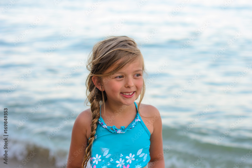 Cute happy smiling little girl play near the sea on a sunny summer day Cute happy smiling little girl play near the sea on a sunny summer day