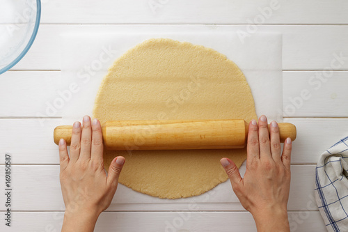 Step by step recipe galette or pie with nectarines. Female hands roll out the dough with a rolling pin.