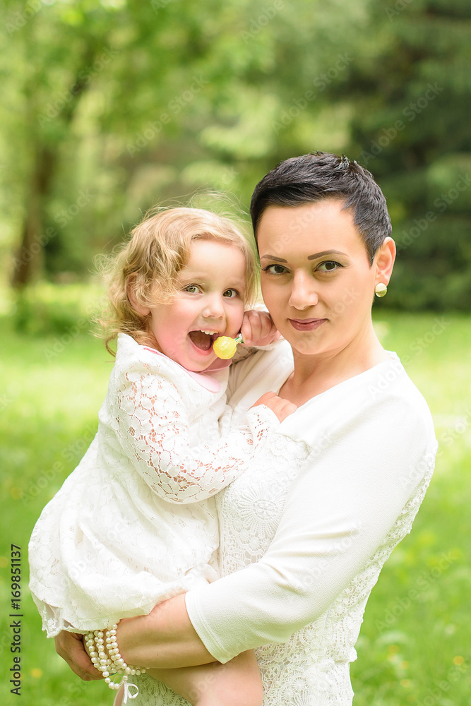 Beautiful child with mom in the summer. Green nature background Beautiful child with mom in the summer. Green nature background