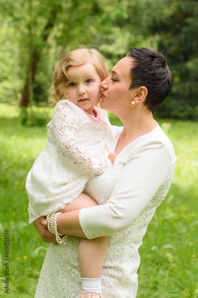 Beautiful child with mom in the summer. Green nature background Beautiful child with mom in the summer. Green nature background