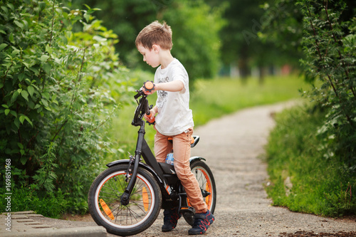 Fototapeta Naklejka Na Ścianę i Meble -  the boy is riding a bike on the street