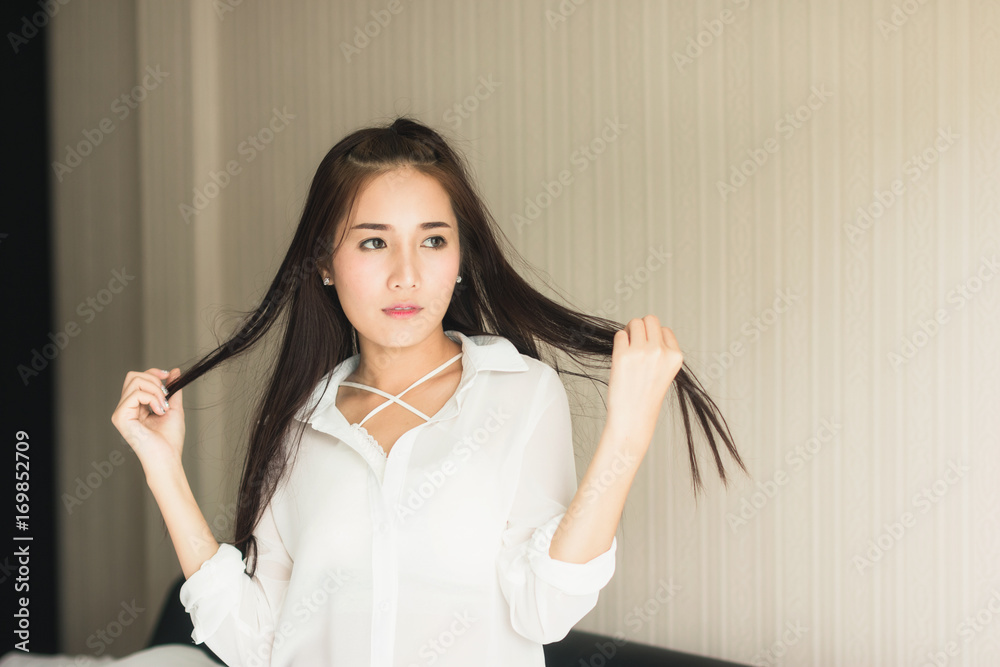 Beautiful Asian woman wearing white dress looking good Relax in the bedroom. Beautiful Asian woman wearing white dress looking good Relax in the bedroom.
