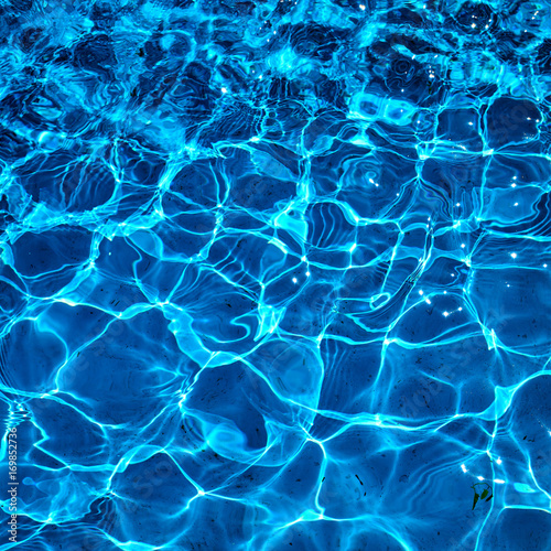 Water in swimming pool with sun reflection. Blue water. Water abstract background