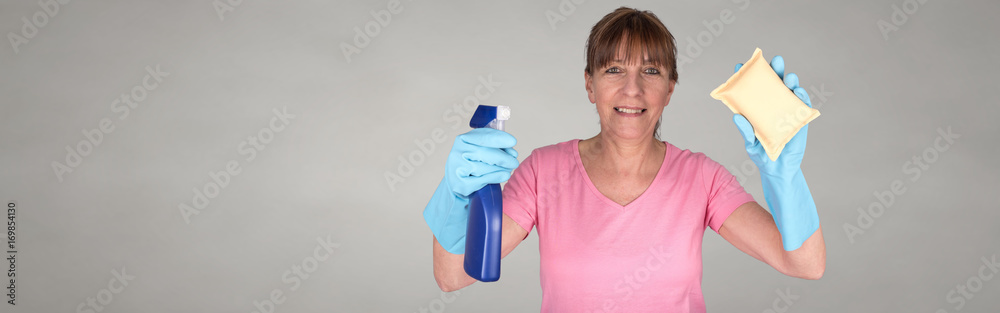 Housewife using a sponge and a windows cleaning spray Housewife using a sponge and a windows cleaning spray
