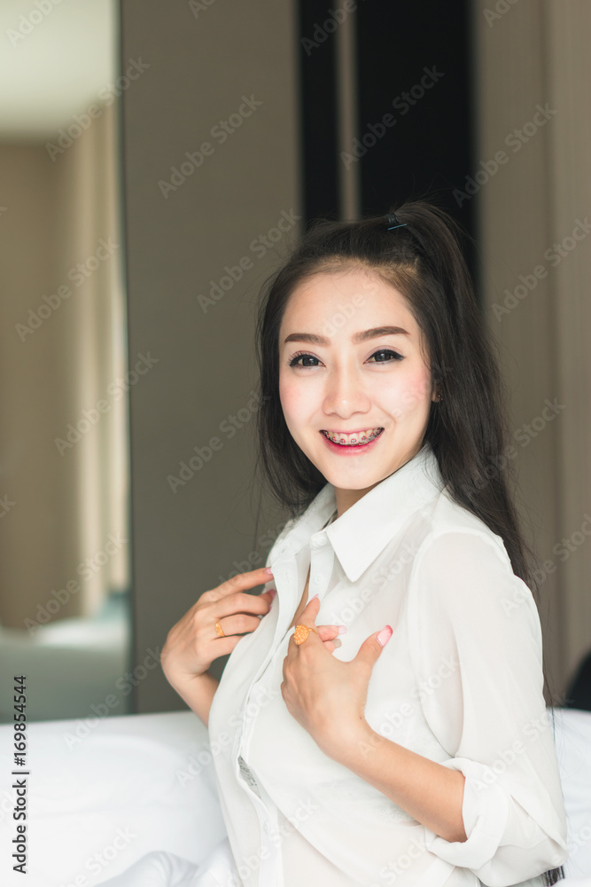 Beautiful Asian woman wearing white dress looking good Relax in the bedroom. Beautiful Asian woman wearing white dress looking good Relax in the bedroom.