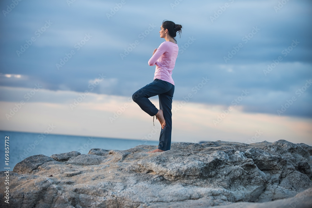 Beautiful woman practicing yoga on the beach at sunrise Beautiful woman practicing yoga on the beach at sunrise