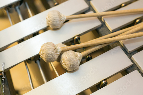 xylophone, musical chromatic instruments concept - closeup on wooden bars with mallets, glockenspiel, marimba, balafon, semantron, pixiphone, education and orchestra concert usage, top view.