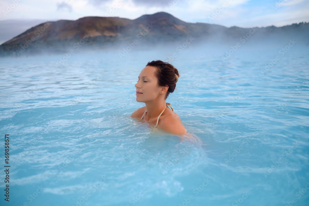 Woman enjoys spa in geothermal hot spring Woman enjoys spa in geothermal hot spring