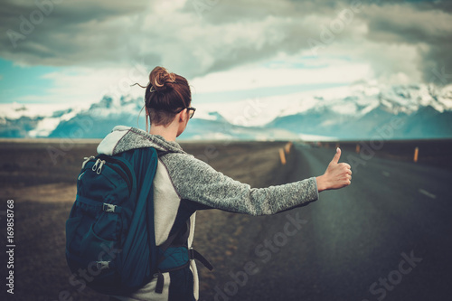 Tableau sur toile Travel hitchhiker woman walking on a road