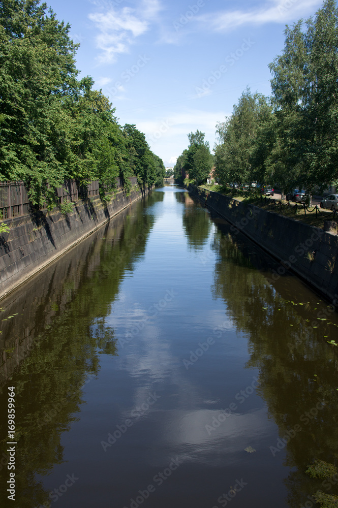 Kronstadt, Ruusia - July 16, 2014. A canal with green trees in Kronstadt. Kronstadt is city-fortress in the Baltic Kronstadt, Ruusia - July 16, 2014. A canal with green trees in Kronstadt. Kronstadt is city-fortress in the Baltic