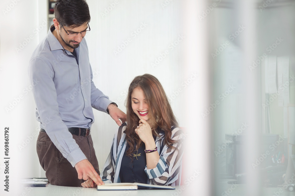 Fototapeta premium Young manager and his assistant are working in the office