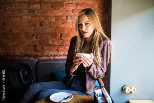 woman in a cafe drinking coffee in the morning photo