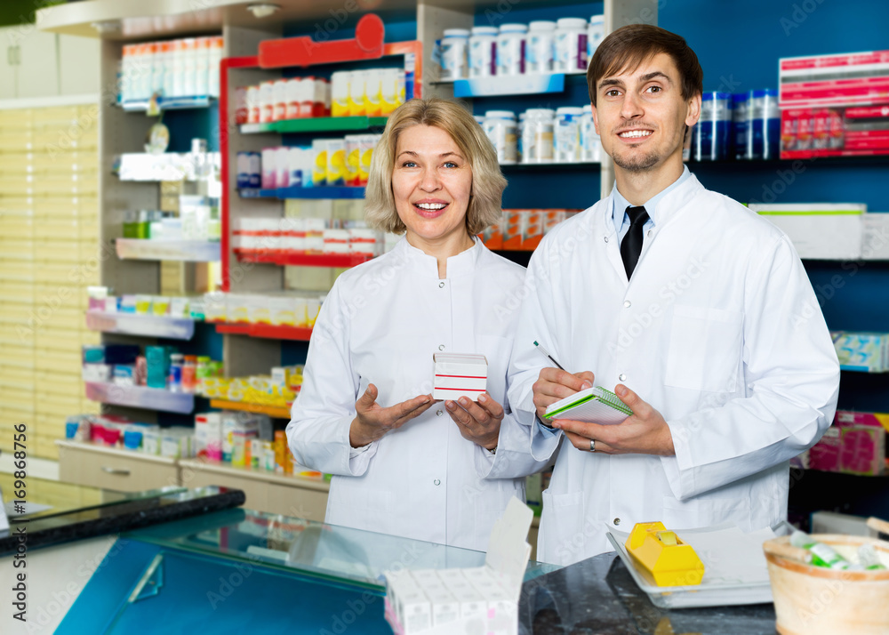 Portrait of two pharmacists working in modern farmacy