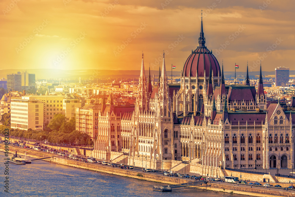 Travel and european tourism concept. Parliament and riverside in Budapest Hungary with sightseeing ships during summer day sunset.
