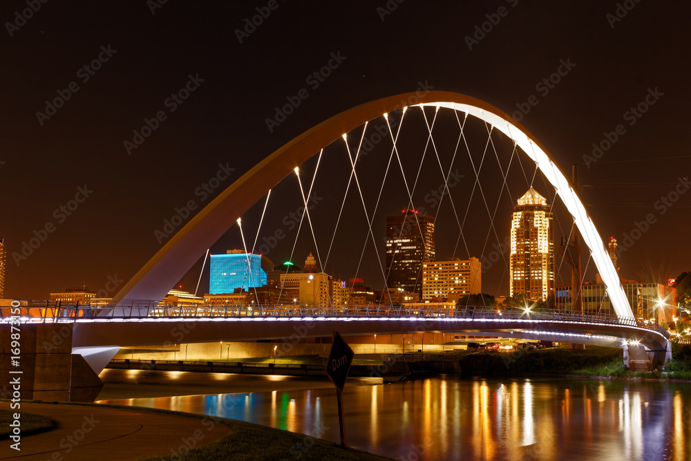 One of the central features of Des Moines is the Iowa Women of Achievement Bridge that spans the Des Moines River. Through the lit arch, the skyline of Des Moines is clearly visible.