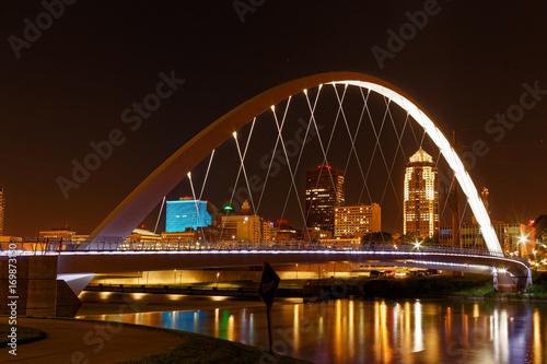 One of the central features of Des Moines is the Iowa Women of Achievement Bridge that spans the Des Moines River. Through the lit arch, the skyline of Des Moines is clearly visible. photo