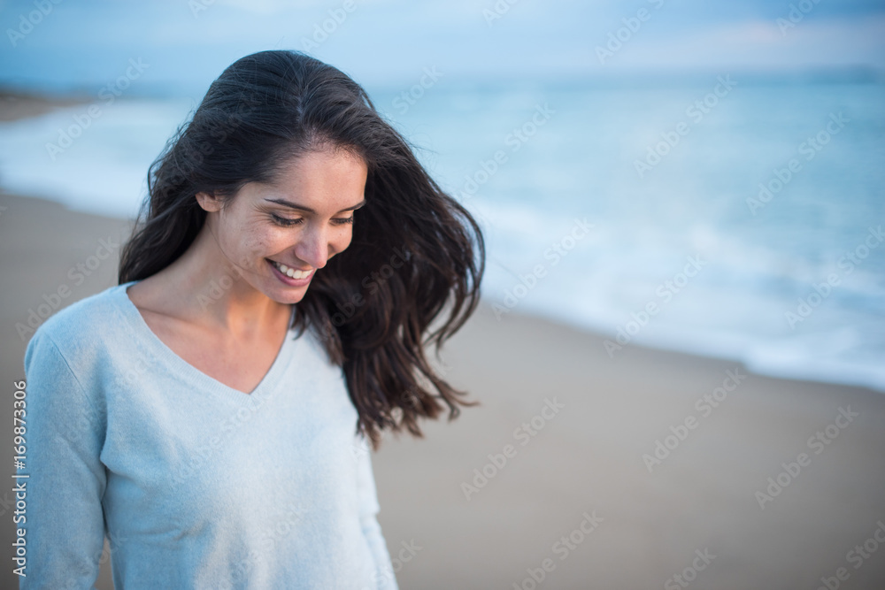 Portrait of a brunette with long hair walking on the beach Portrait of a brunette with long hair walking on the beach