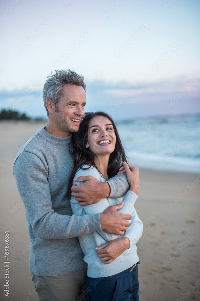 Obraz premium Beautiful couple on the beach at sunset