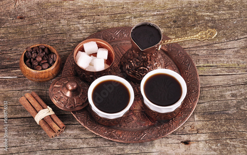 Coffee in copper coasters with accessories for coffee-drinking on old wooden background photo