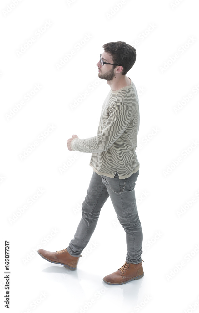 Naklejka premium side view. modern young man confidently goes forward.