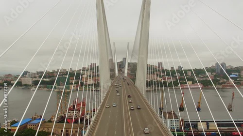 Amazing zooming out aerial view of the Zolotoy Bridge (the Golden Bridge) that is cable-stayed bridge across the Zolotoy Rog built in 2012 in Vladivostok, Russia, and cars driving on it. 4k photo