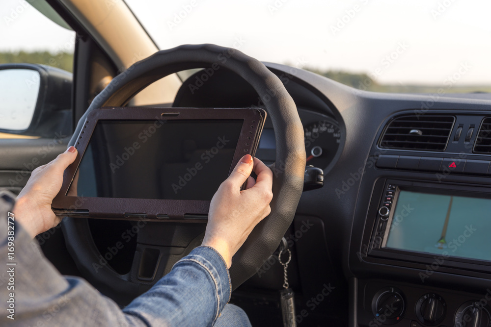 Girl holding mobile phone with gps application in the car with tablet screen computer