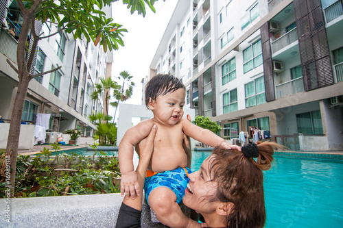 The kid and mom play together in the pool