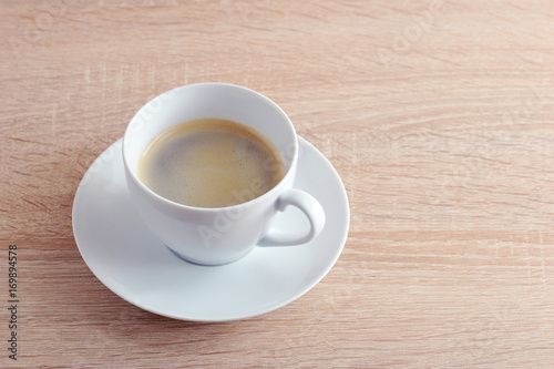 coffee in white Cup with saucer on a wooden background