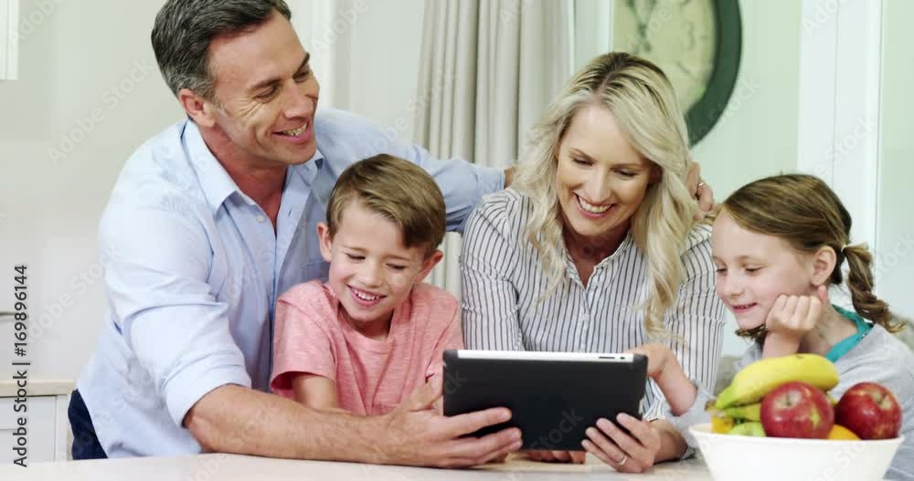 Smiling family using digital tablet together in living room Smiling family using digital tablet together in living room