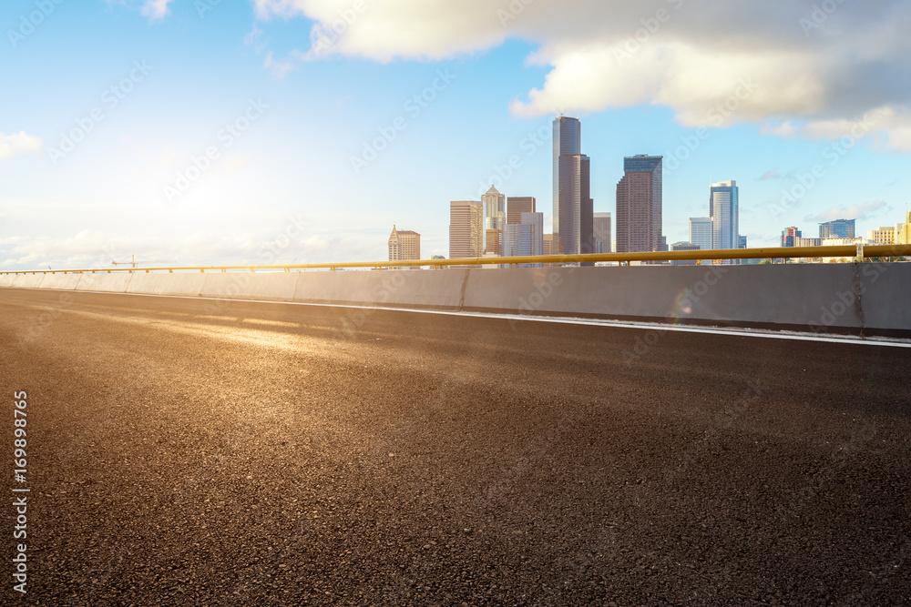empty road with cityscape of modern city in blue sky empty road with cityscape of modern city in blue sky