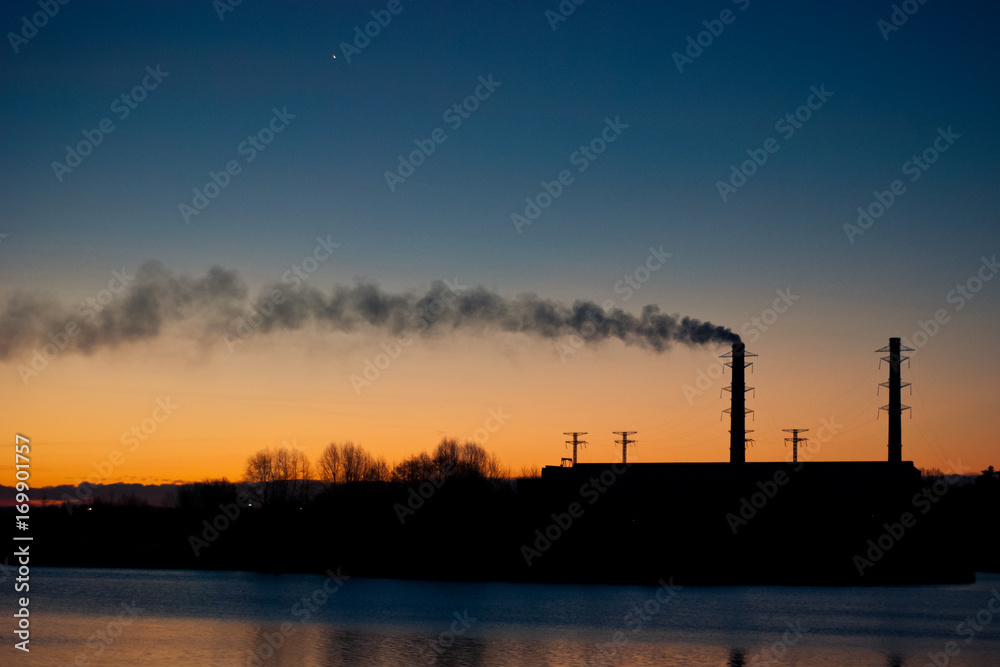 View of the power station near the water at dawn
