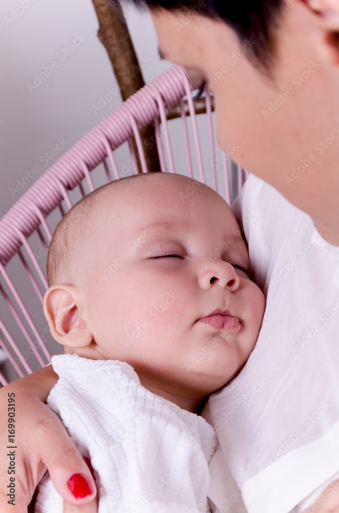 Happy mother with sleeping newborn baby
