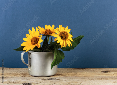 Canvas Print Wild flowers in an aluminum mug on a wooden table