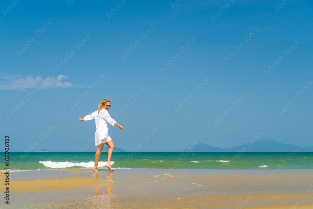 woman walking to the water on the beach