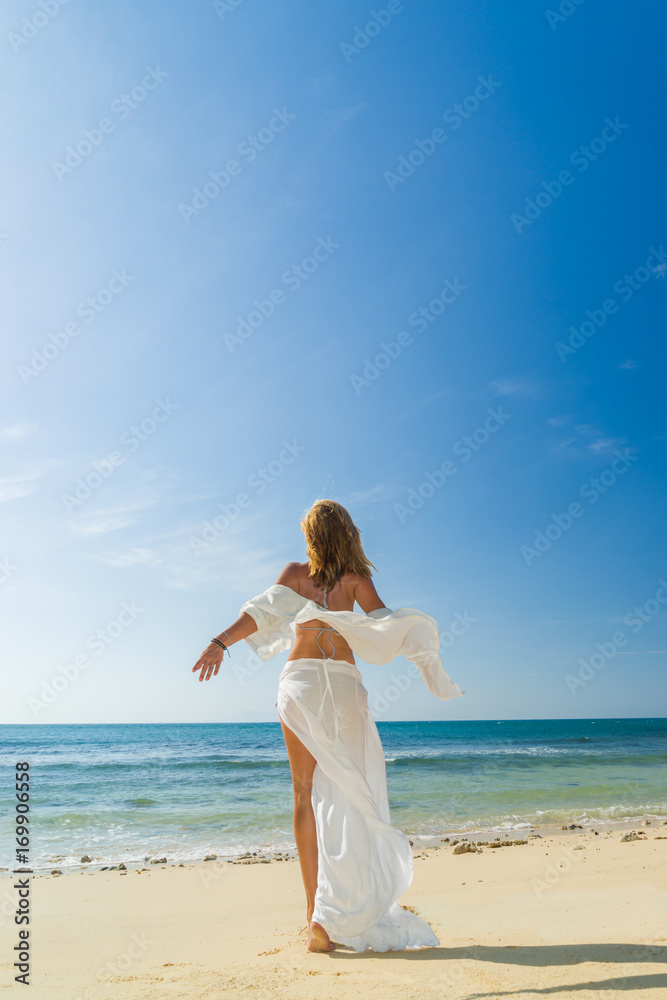 woman walking to the water on the beach woman walking to the water on the beach