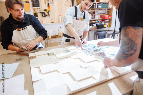 Fotografia Craftsmans standing proudly in workshop alongside a wood and glass display case