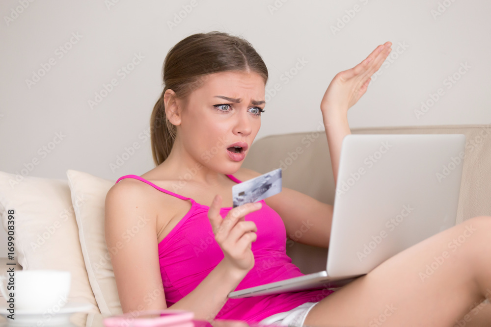 Upset woman with credit card in hand looking on laptop pc screen with confusion while shopping at home. Credit card blocking, internet fraud, empty bank account, online payment mistake, spent too much Upset woman with credit card in hand looking on laptop pc screen with confusion while shopping at home. Credit card blocking, internet fraud, empty bank account, online payment mistake, spent too much