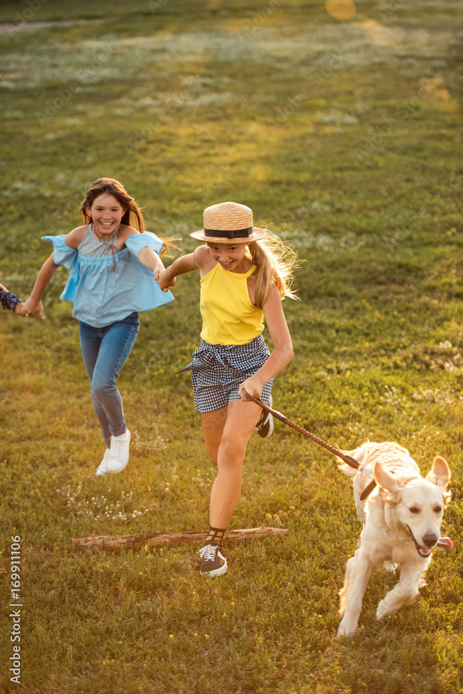 teenagers running with dog