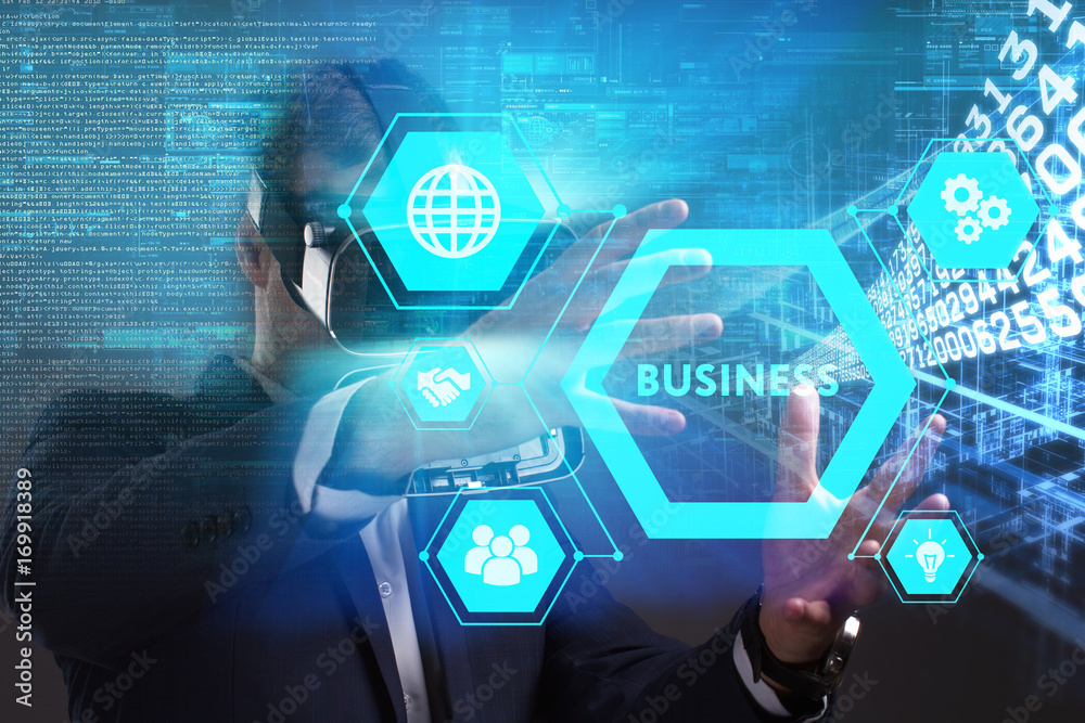 Business, Technology, Internet and network concept. Young businessman working in virtual reality glasses sees the inscription: Business Business, Technology, Internet and network concept. Young businessman working in virtual reality glasses sees the inscription: Business