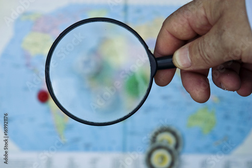 Magnifying glass on the background of the world map 