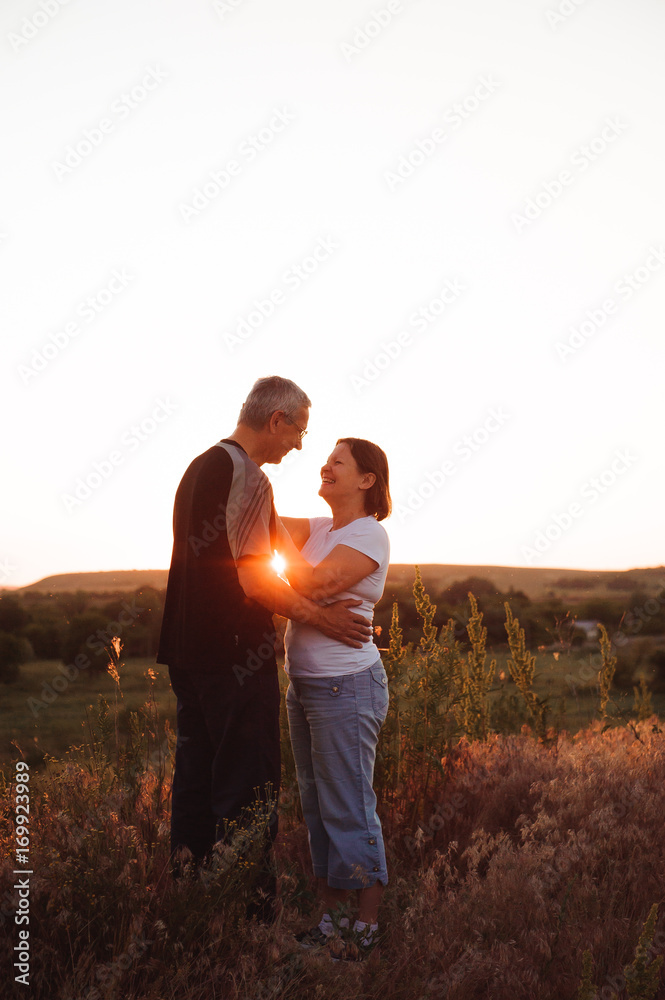 Couple holding hands at sunset enjoying romance and sun.