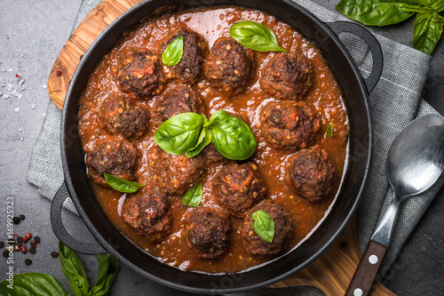 Meatballs in tomato sauce on a black background.