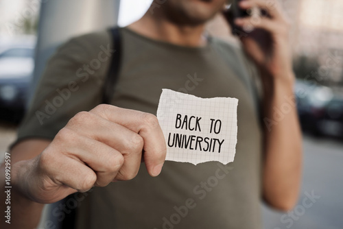 man with a note with the text back to university