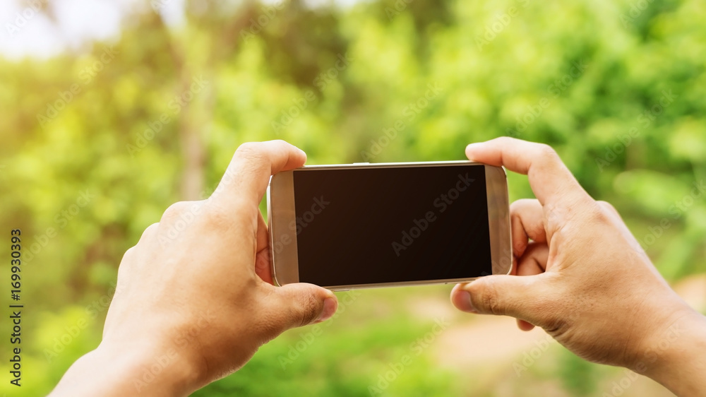 Man holding a smartphone for taking a picture.