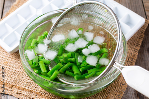 Boiled vegetables, green beans  in ice water after blanching